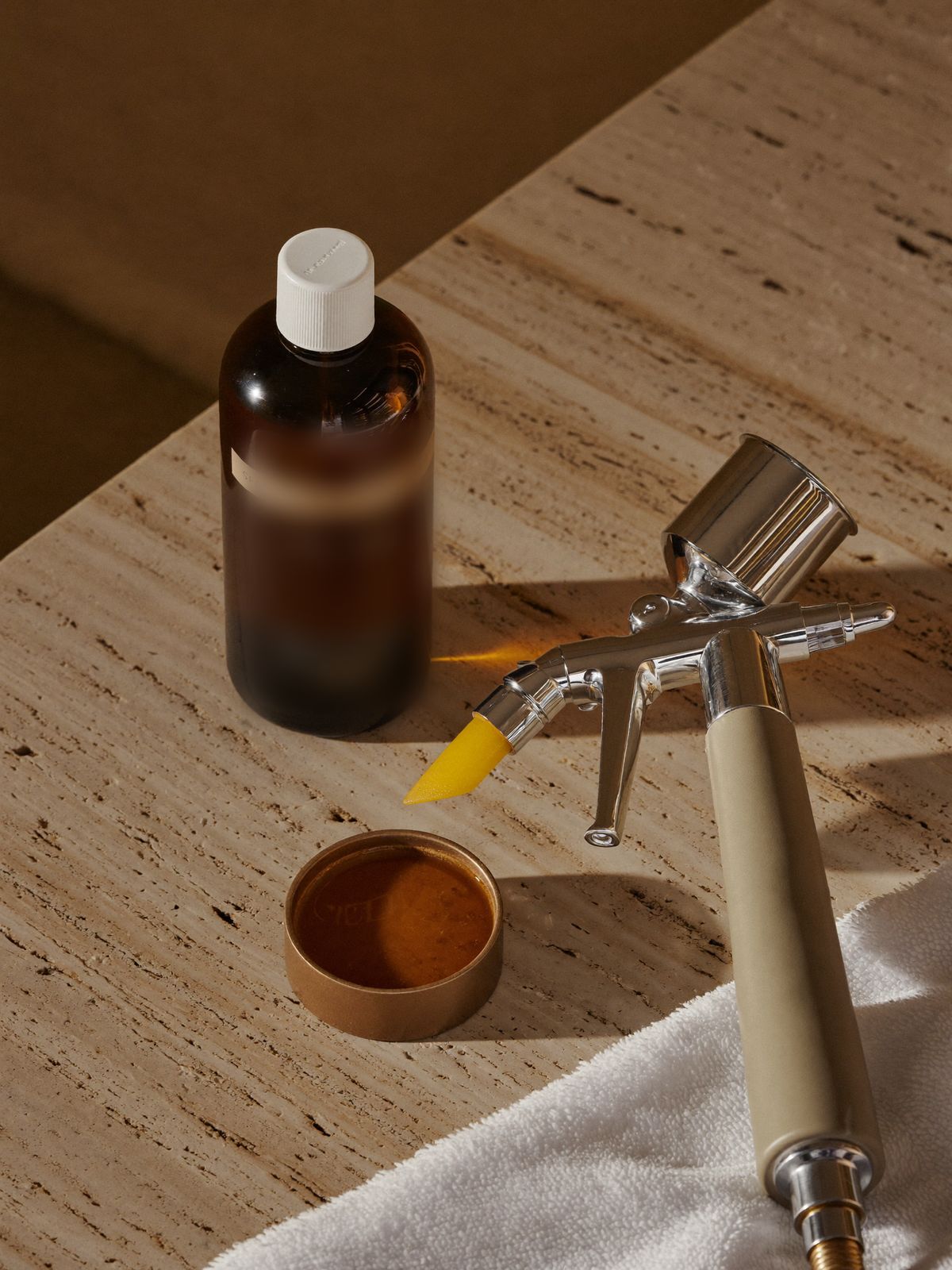 Spray tan airbrush and bronze tanning solution on stone